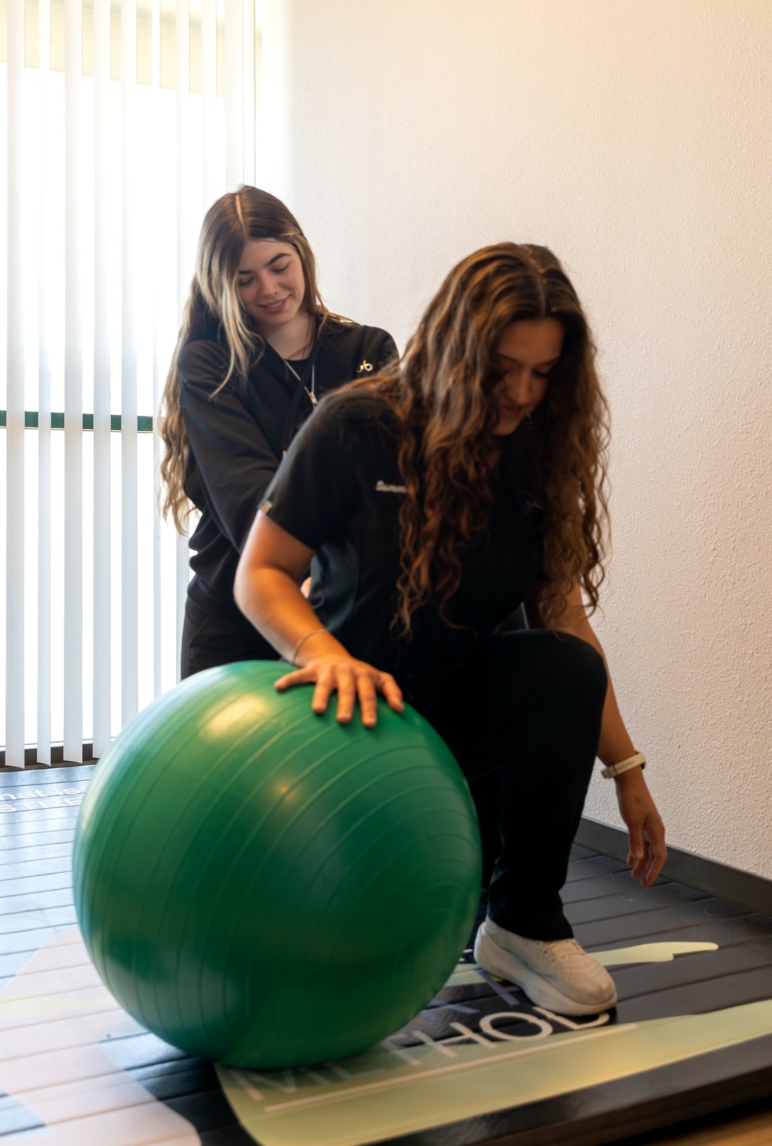 A patient working on a stability ball with guidance from the team at Simi Valley Spine & Wellness